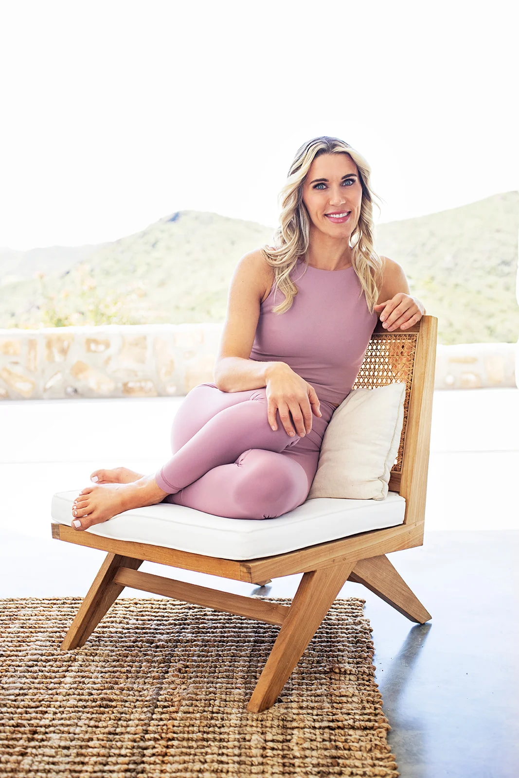 Courtney Virden is sitting in mauve leggings with pockets on the chair.